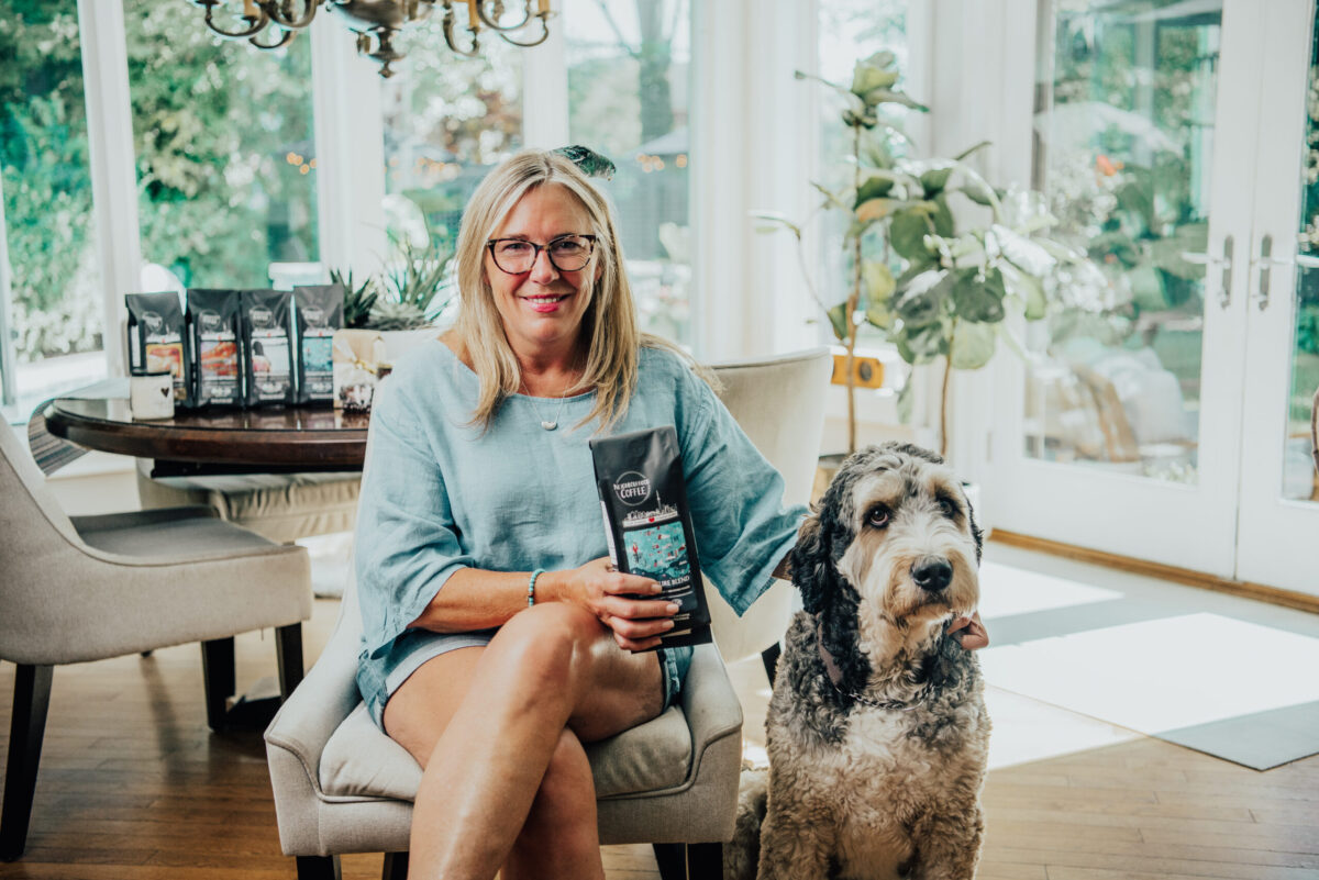 Owner of Neighbourhood Coffee, Karen Hales, holding a bag of Signature Roast in her Toronto home.