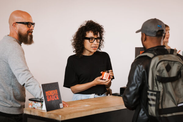 Monster sauce owners talking to an attendee at Canadians Connected: Edmonton