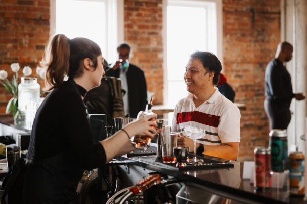 Someone smiling ordering a drink at Canadians Connected