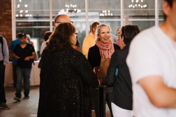 A woman smiling in the crowd at Canadians Connected: Edmonton