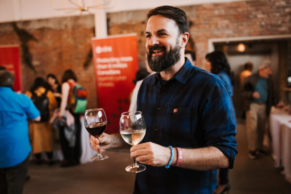 Man smiling with two wine glasses