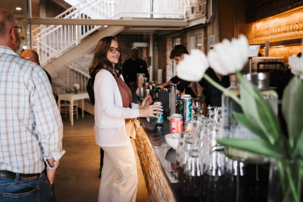 A woman ordering a drink at a bar smiling