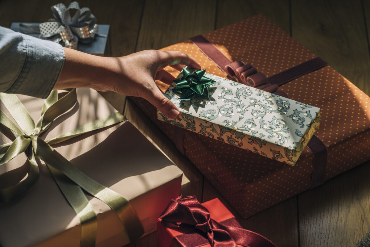 A woman holding a perfectly wrapped Christmas present