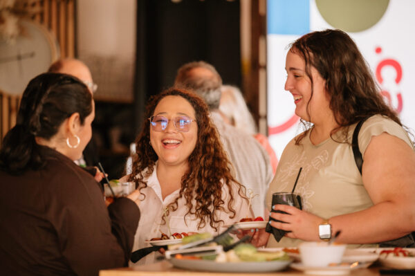 Three women smiling and having a drink