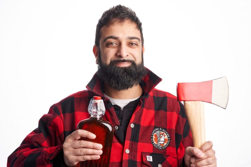 Lumberjack shows off bottle of maple syrup