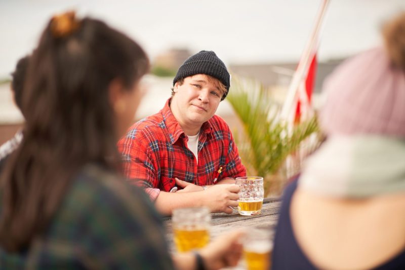 Man in plaid shirt enjoys beer