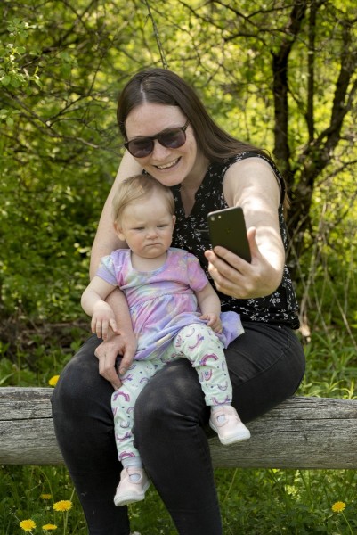 Mom taking a selfie with baby while on a forest hike